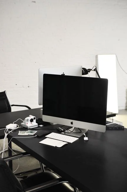 Un homme travaille sur la conception web dans un bureau à domicile, installé avec deux écrans.